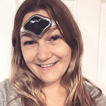a smiling woman wearing a CEFALY device on her forehead